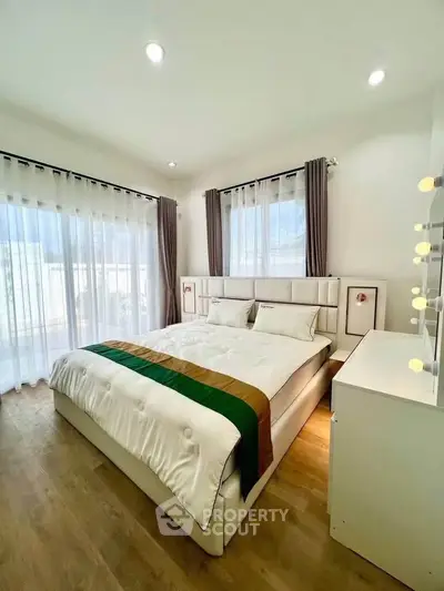 Bright and cozy bedroom with elegant decor and large windows for natural light.