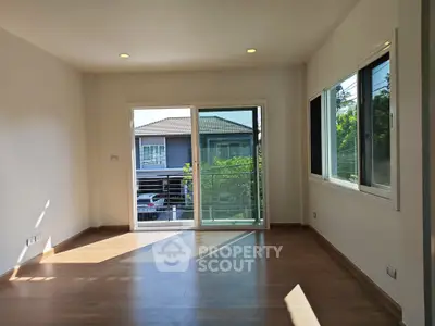 Bright and spacious living room with large windows and wooden flooring