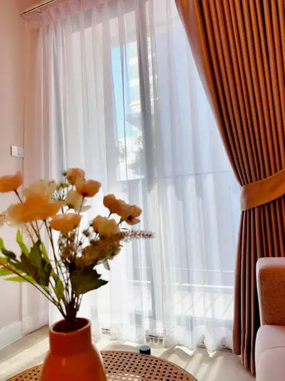 Bright living room with elegant curtains and a cozy seating area, perfect for relaxation.