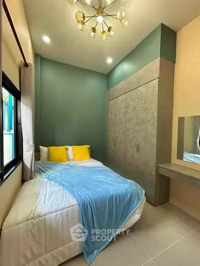 Cozy bedroom with modern decor, featuring a stylish chandelier and built-in wardrobe.