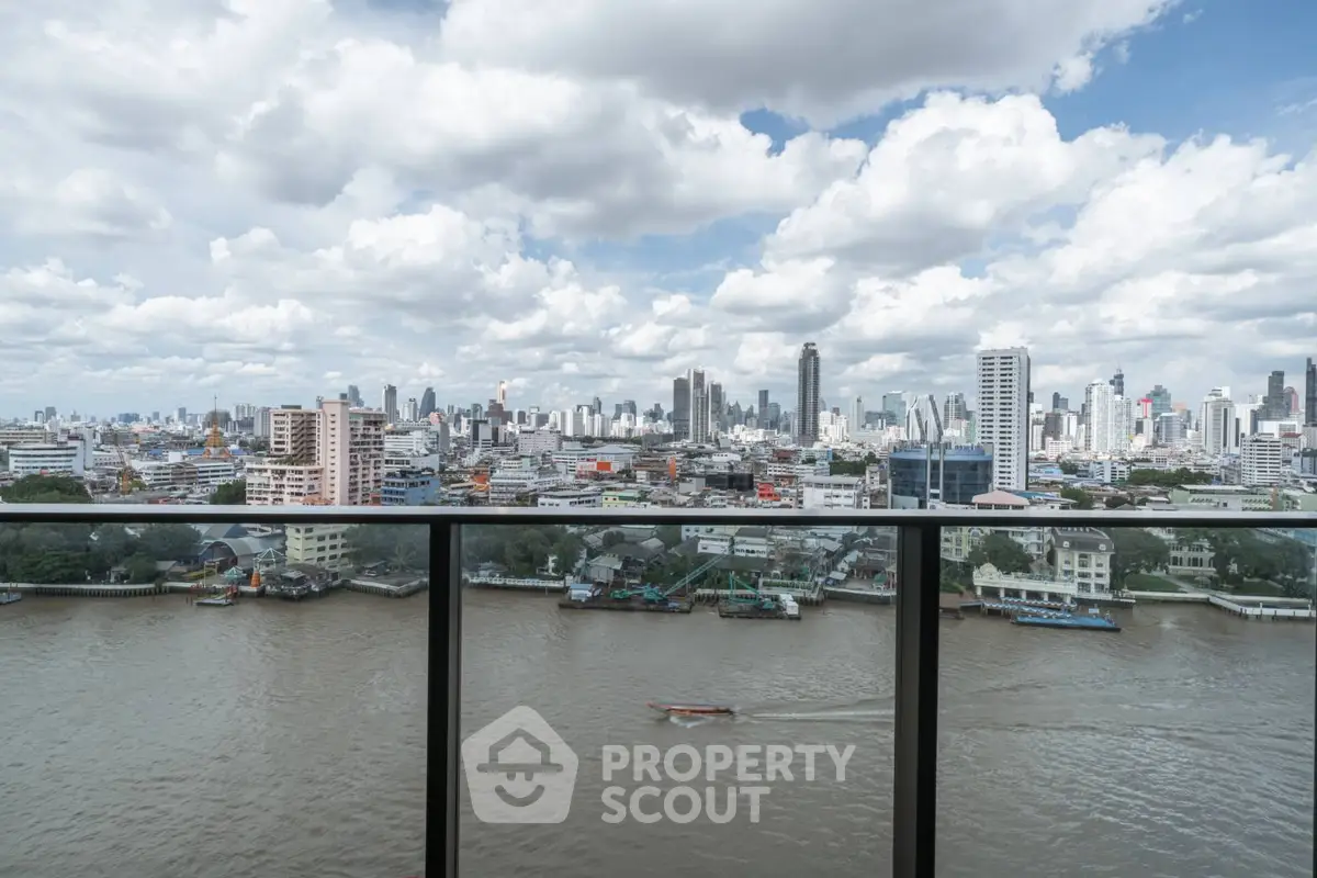 Stunning cityscape view from a high-rise balcony overlooking a river.