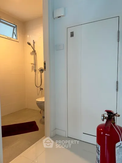 Modern bathroom with sleek shower and fire extinguisher in minimalist design