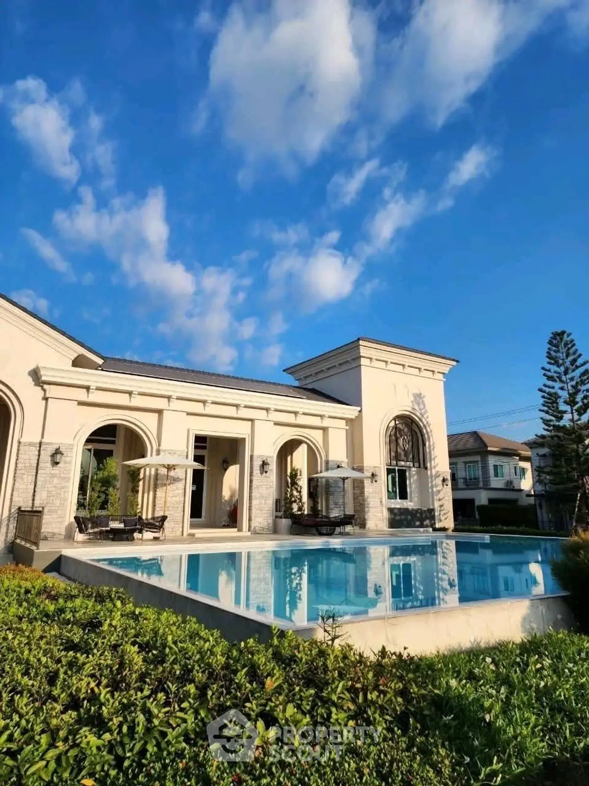 Luxurious villa with stunning pool and elegant architecture under blue sky.