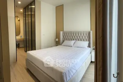 Luxurious bedroom with elegant decor and plush bedding in modern apartment.