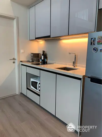 Modern kitchen with sleek cabinetry and built-in microwave