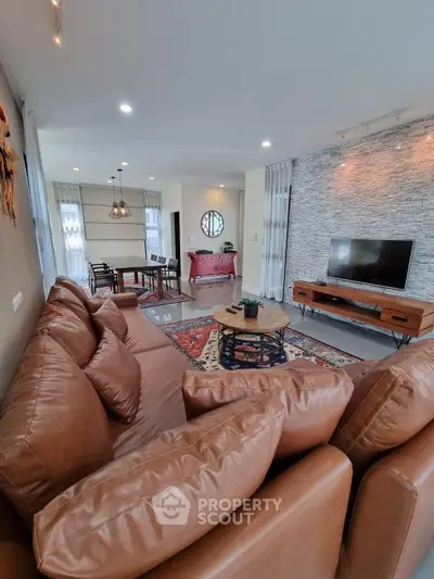 Spacious living room with modern decor and leather sofas in a stylish apartment.