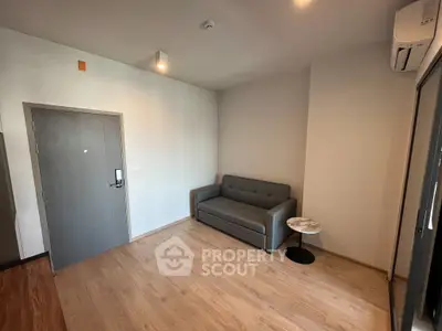 Modern minimalist living room with gray sofa and sleek wooden flooring