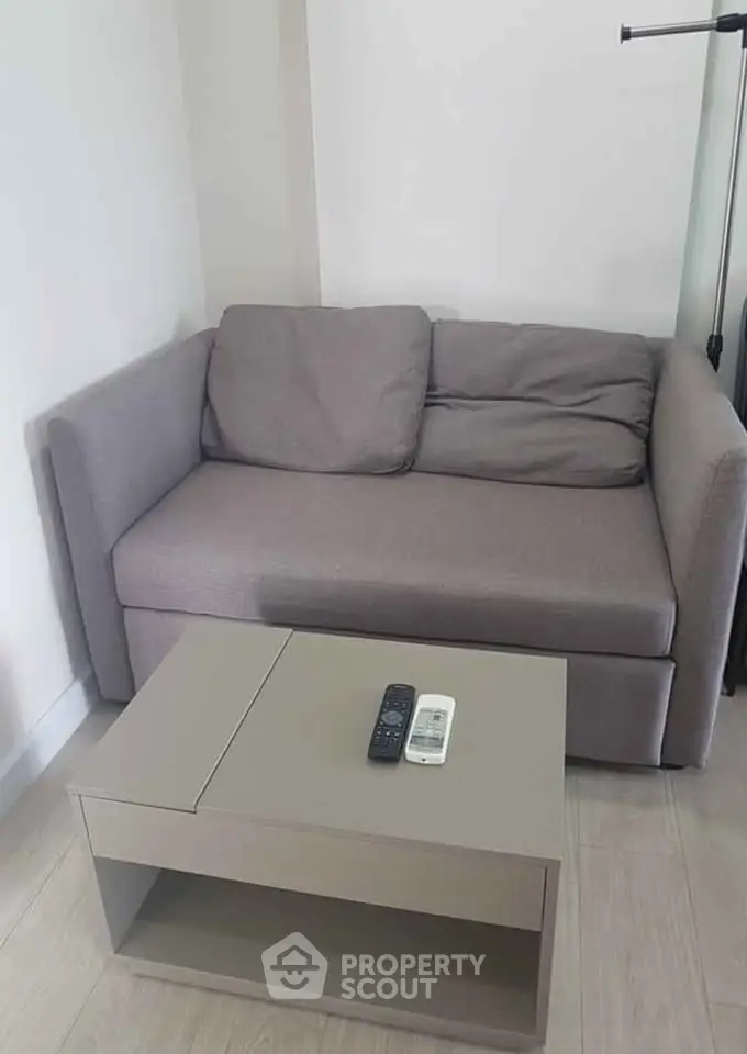 Cozy living room with modern gray sofa and sleek coffee table, perfect for relaxation.