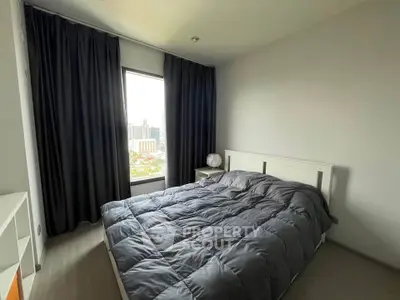 Cozy bedroom with modern decor and city view, featuring a comfortable bed and dark curtains.
