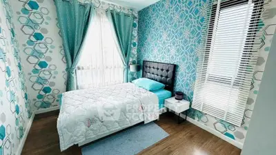 Charming bedroom with modern geometric wallpaper and cozy bed setup.