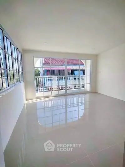 Spacious bright room with large windows and balcony access, perfect for natural light lovers.