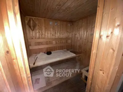 Cozy wooden sauna room with bench seating and warm ambiance.