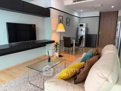 Modern living room with sleek furniture and open kitchen layout in a stylish apartment.