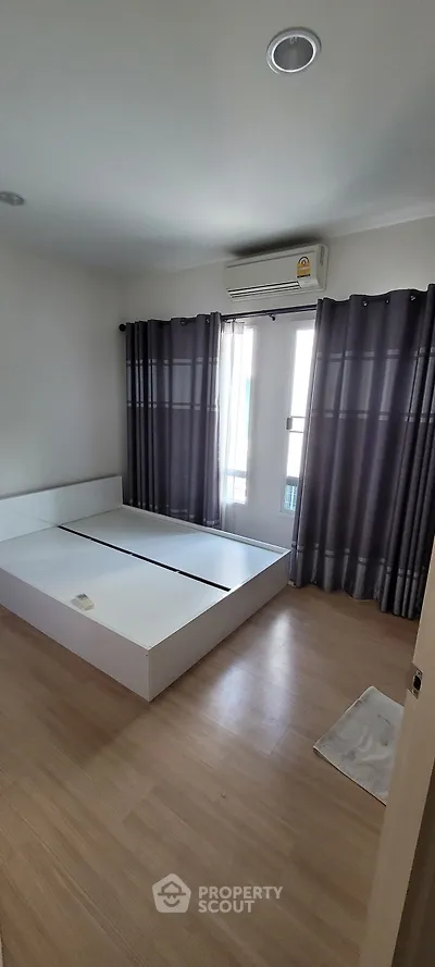 Spacious bedroom with modern design and large windows for natural light.