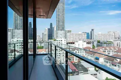 Stunning cityscape view from a modern high-rise balcony with glass railing.