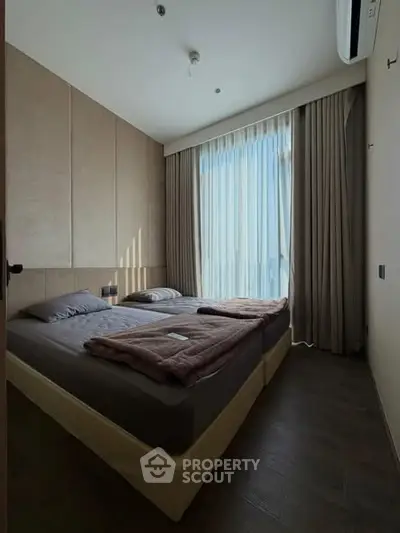 Cozy bedroom with large window and modern decor, perfect for relaxation and comfort.