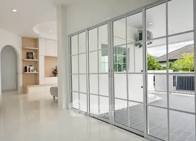 Modern living room with sliding glass doors opening to a spacious balcony, featuring sleek design and natural light.