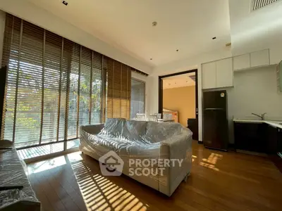 Spacious living room with modern kitchen and large windows for natural light