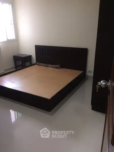 Spacious bedroom with modern bed frame and natural light
