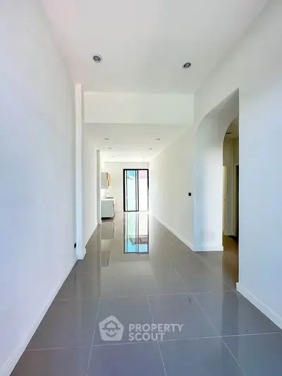 Spacious modern hallway with glossy tiles and natural light