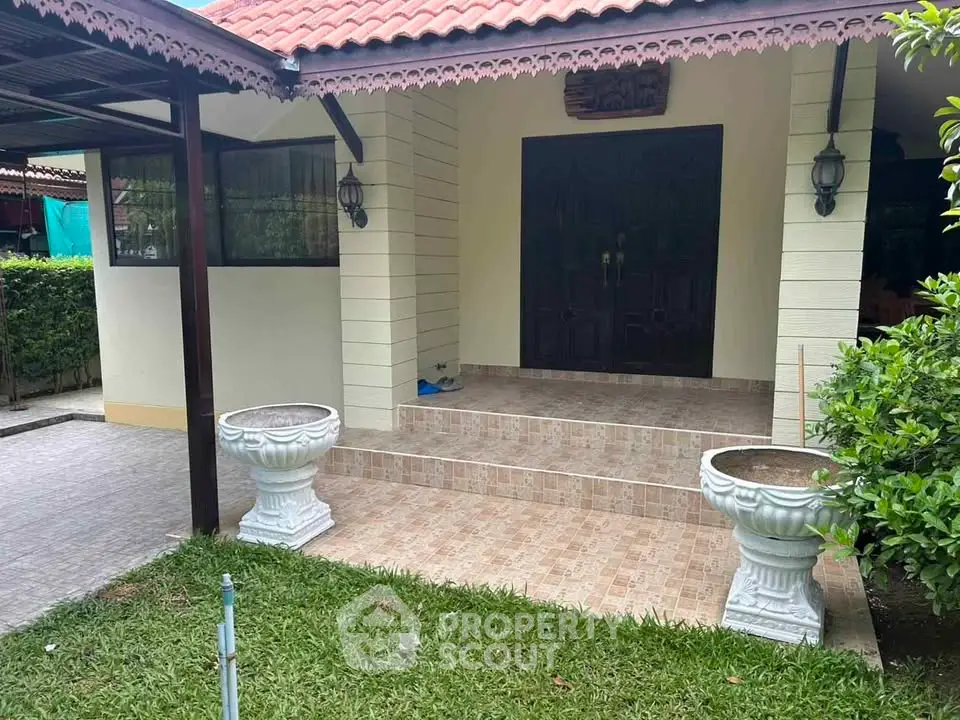Charming entrance with tiled steps and lush greenery, perfect for a welcoming home ambiance.