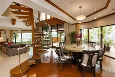 Luxurious living room with spiral staircase and elegant dining area, featuring large windows and stylish decor.