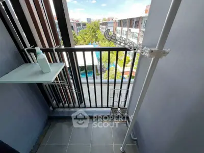 Charming balcony with pool view in modern apartment complex, perfect for relaxation and enjoying the scenery.