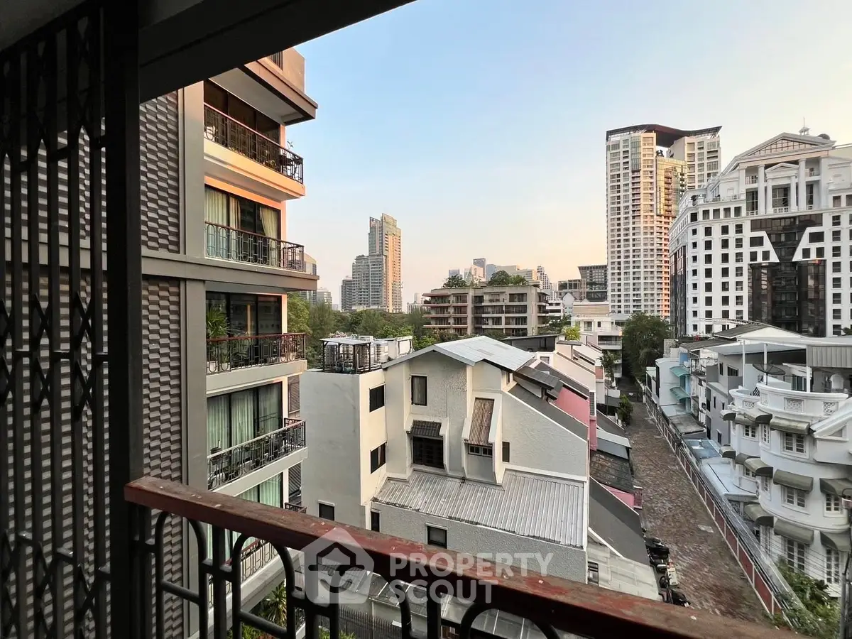 Stunning urban view from a high-rise balcony overlooking city skyline and modern architecture.