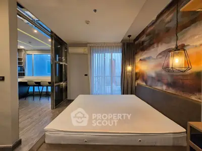 Modern bedroom with artistic wall, open kitchen layout, and large window for natural light.