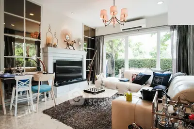 Luxurious living room with elegant decor and large windows offering garden views.