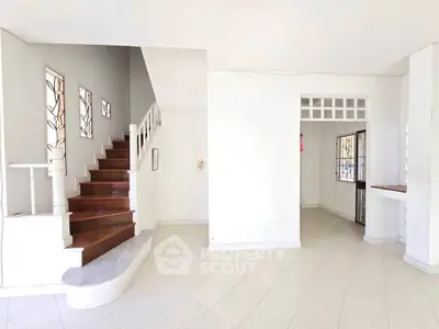 Spacious interior with elegant staircase and tiled flooring, perfect for modern living.