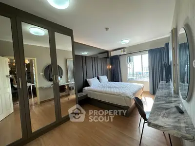Spacious bedroom with mirrored wardrobe and elegant decor in modern apartment