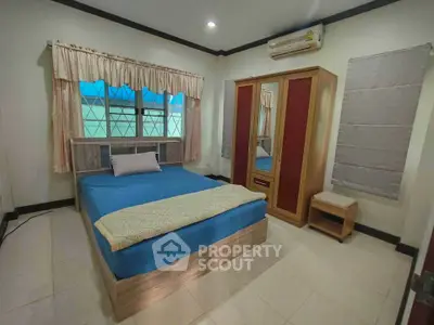 Cozy bedroom with modern furnishings and air conditioning, perfect for comfort and relaxation.