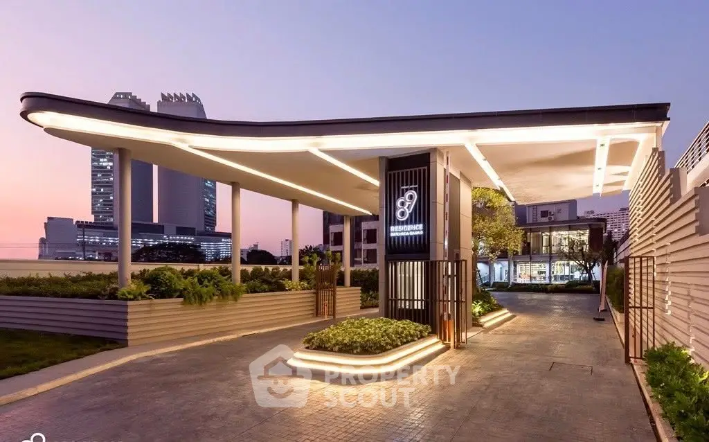 Modern building entrance with sleek design and ambient lighting at dusk.