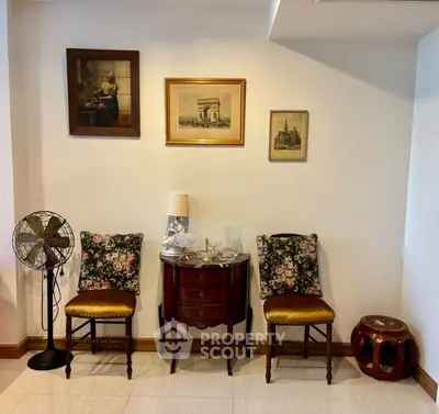 Charming vintage-style living room with elegant chairs and classic wall art