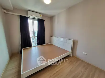 Spacious bedroom with large window and wooden flooring