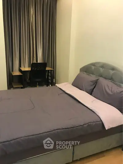 Cozy bedroom with plush bed and study desk, ideal for relaxation and productivity.