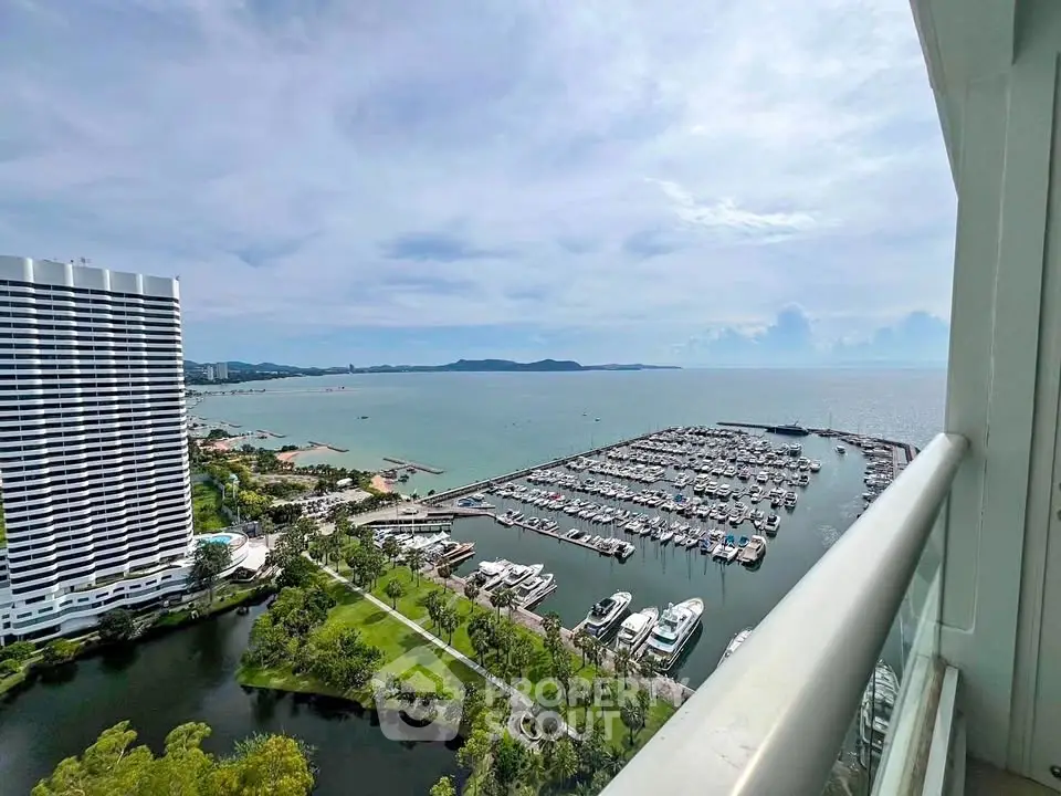 Stunning ocean view from high-rise balcony overlooking marina and cityscape.