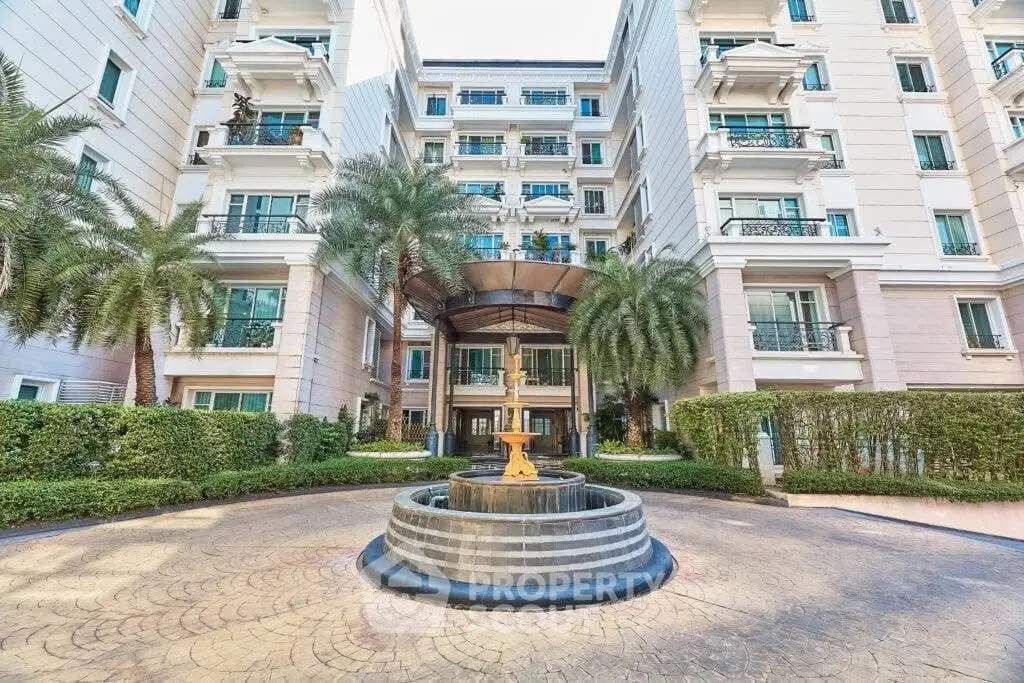 Luxurious apartment building entrance with elegant fountain and lush landscaping