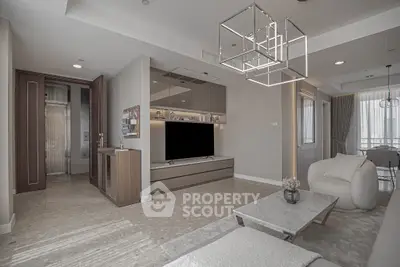 Modern living room with sleek design, featuring a large TV, stylish lighting, and elegant furniture.