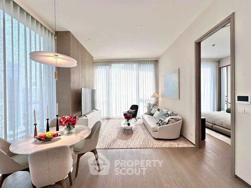 Elegant open-plan living room with dining area, modern furniture, and large windows for natural light.