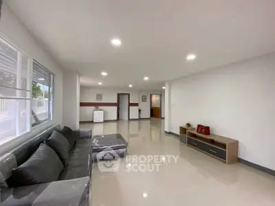 Spacious modern living room with sleek tile flooring and large windows for natural light.