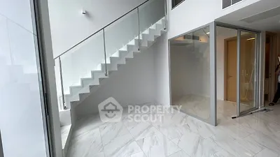 Modern minimalist interior with sleek staircase and glass partitions
