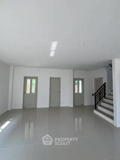 Spacious modern interior with sleek staircase and tiled flooring