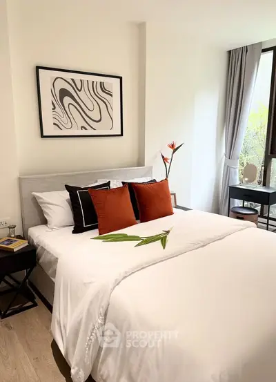 Elegant bedroom with modern decor, featuring a cozy bed, stylish artwork, and natural light from large windows.