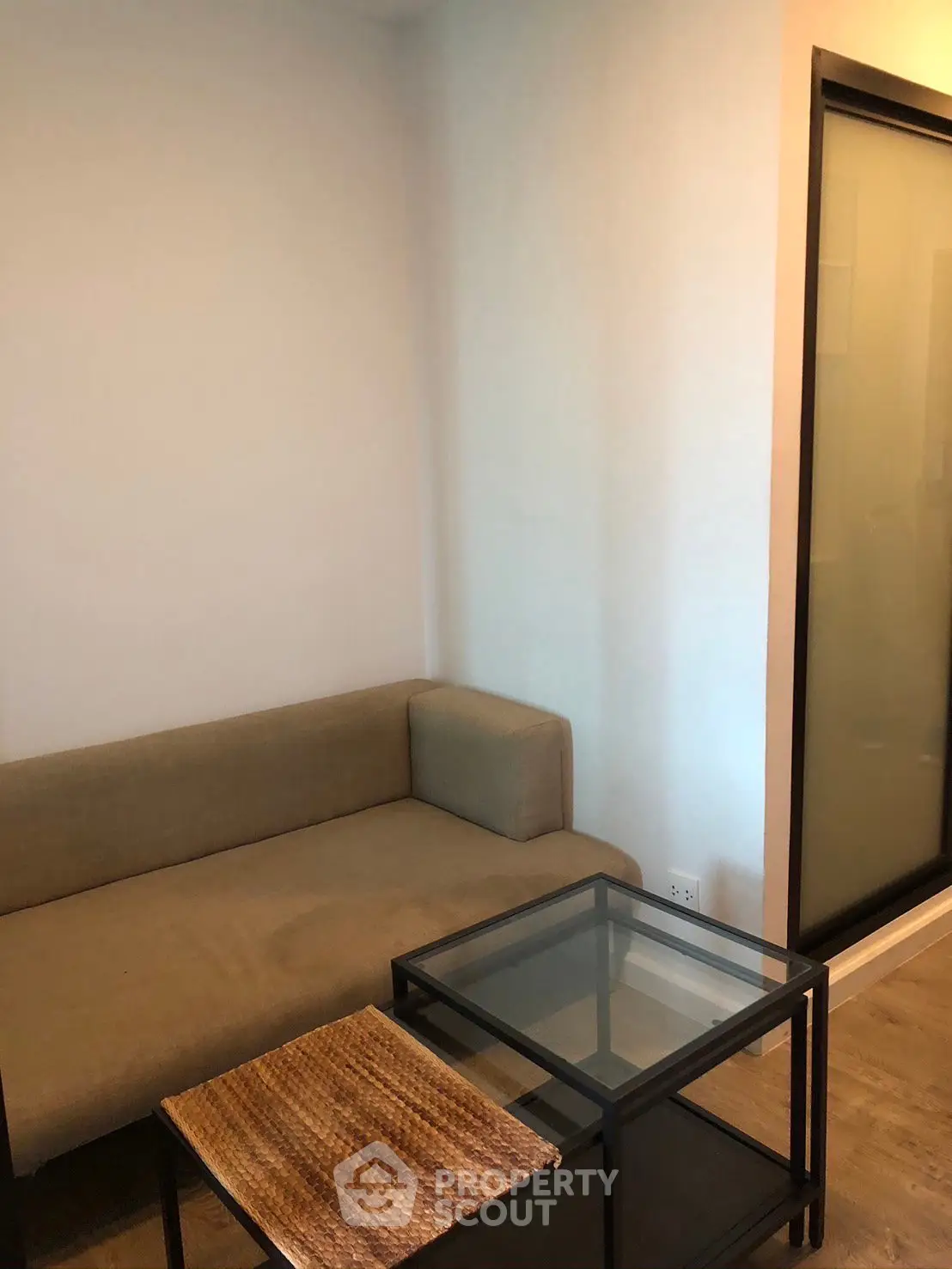 Cozy living room with modern sofa and glass coffee table, perfect for relaxation.