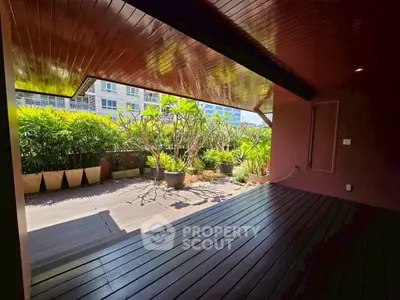 Spacious covered balcony with lush garden view in modern apartment