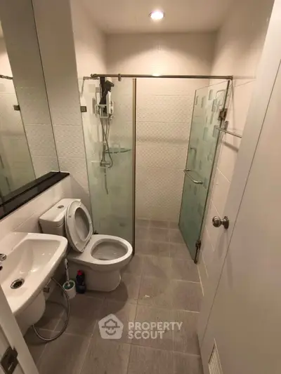 Modern bathroom with glass shower and sleek fixtures in a contemporary apartment.