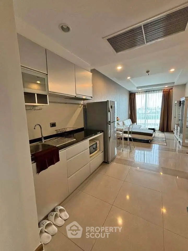 Modern open-layout kitchen and living room with sleek design and natural light.