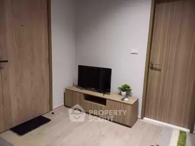 Modern living room corner with TV stand and wooden doors, perfect for cozy home entertainment.